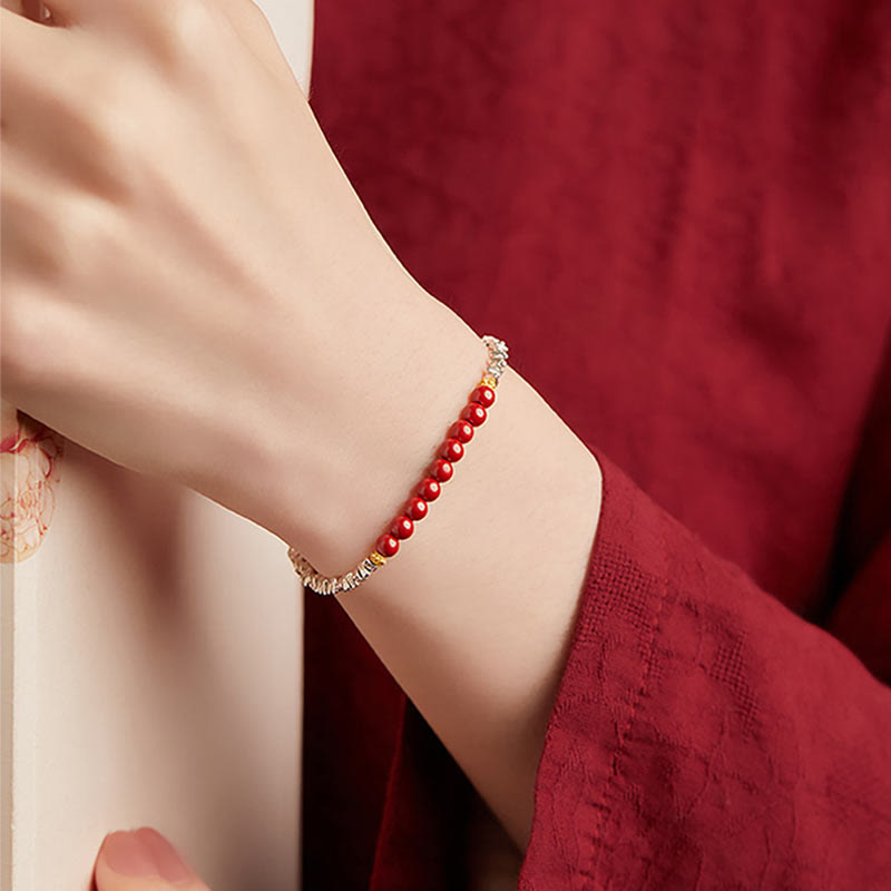 Rotes Armband mit Perlen am Handgelenk elegant getragen.
