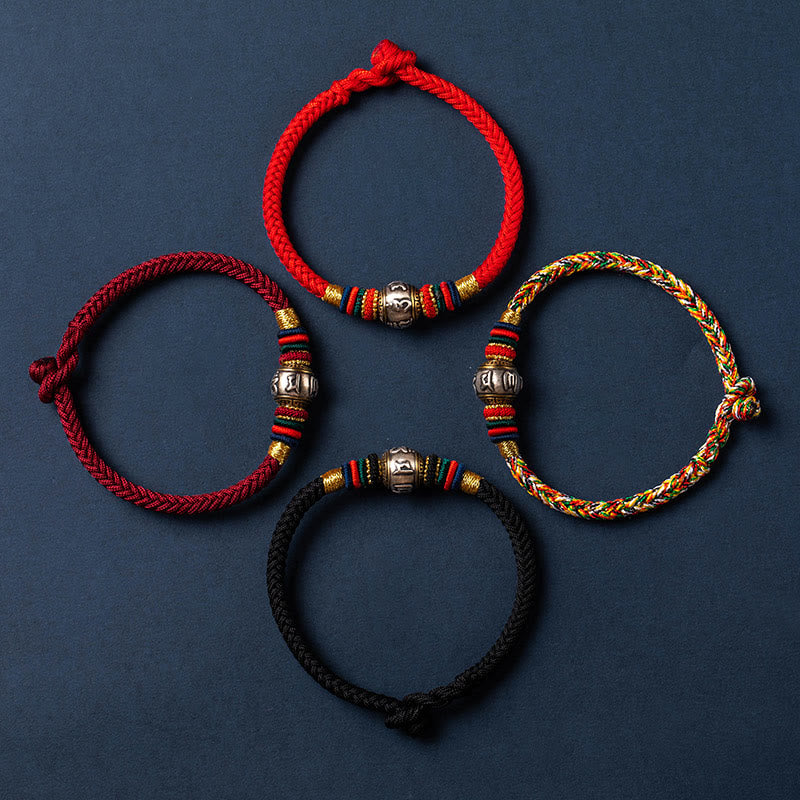 Vier rote und schwarze geflochtene Armbänder mit silbernen Perlen auf blauem Hintergrund.