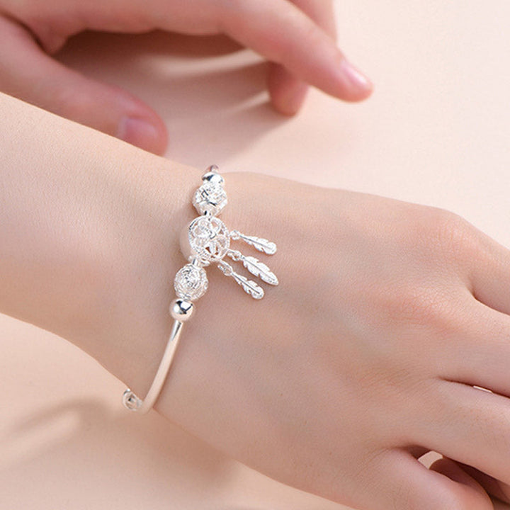 Silbernes Armband mit Kristallperlen und Quasten am Handgelenk getragen