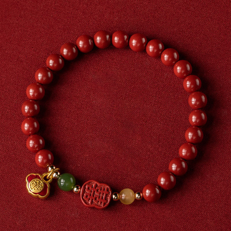 Armband Zinnober – Glück & Ruhe rote Perlen goldene Charms Flachaufnahme