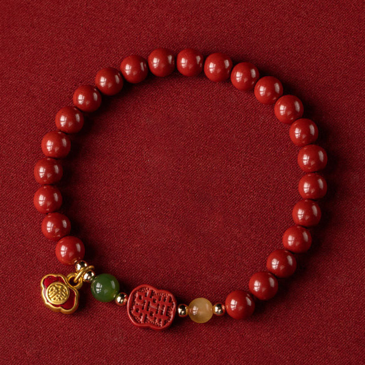Armband Zinnober – Glück & Ruhe rote Perlen goldene Charms Flachaufnahme
