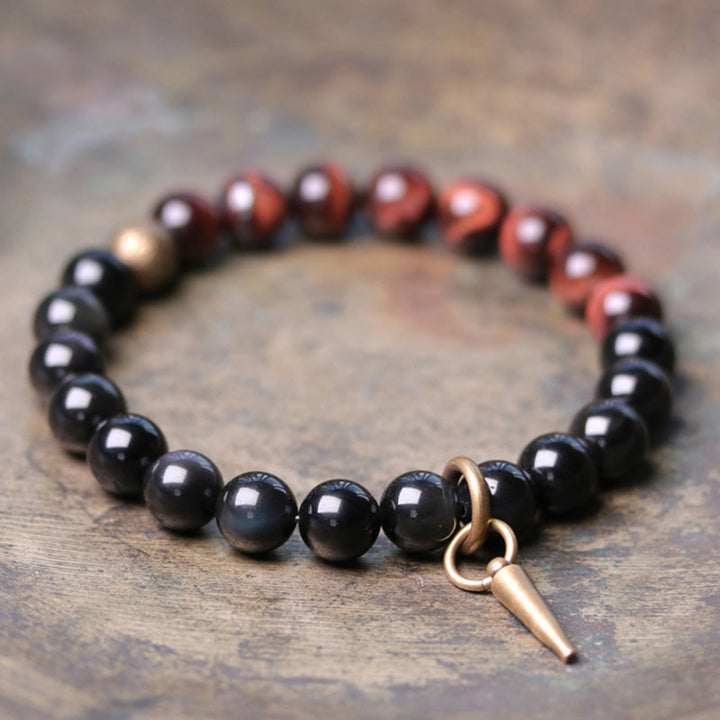 Schwarzer Obsidian Armband mit roten Perlen und bronzener Spitze Anhänger.
