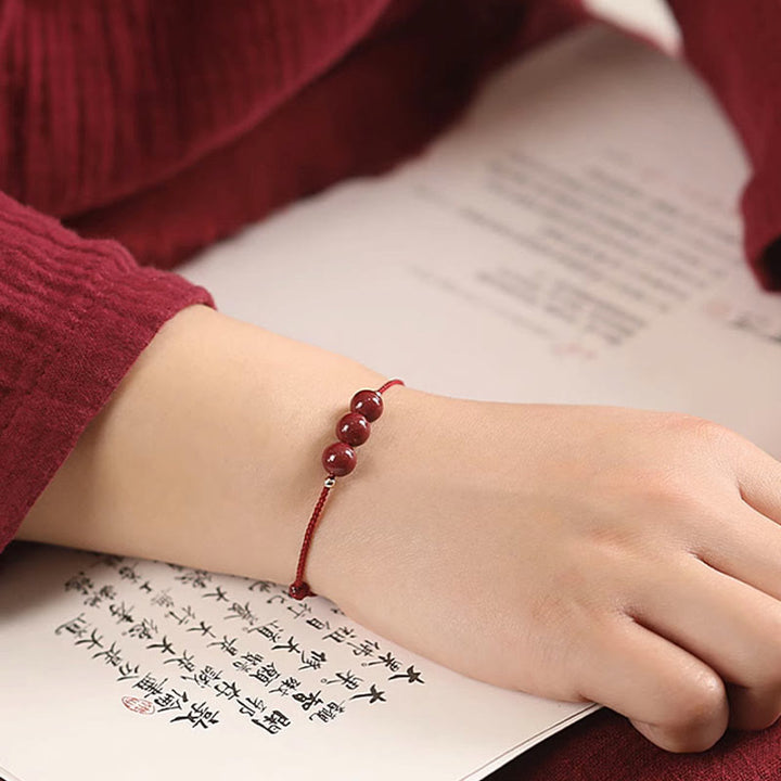 Zinnober Armband am Handgelenk getragen, rote Perlen, elastisch, Glück Segen