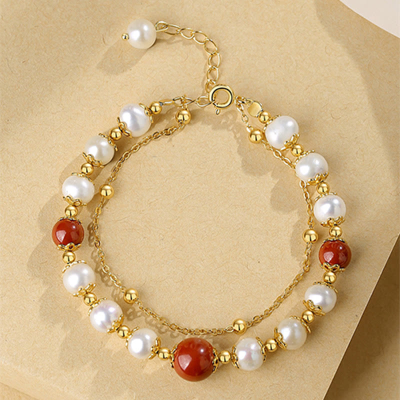 Goldenes Armband mit Perlen und roten Zinnober-Steinen elegant.
