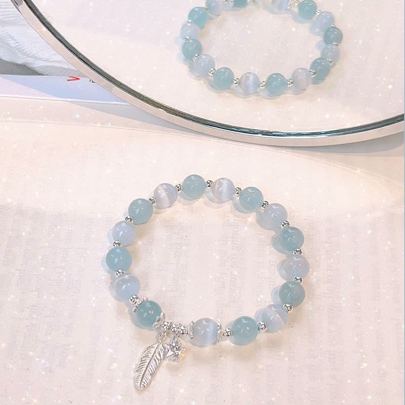 Aquamarin Armband mit Silber Perlen und Feder Anhänger displayed.