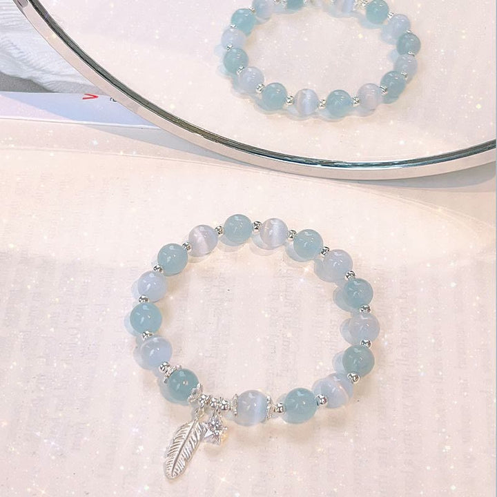 Aquamarin Armband mit Silber Perlen und Feder Anhänger displayed.