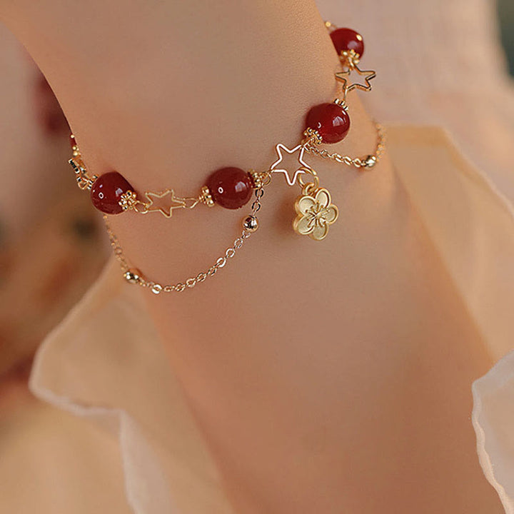 Armband Roter Achat Stern – Ruhe am Handgelenk mit goldenen Charms getragen