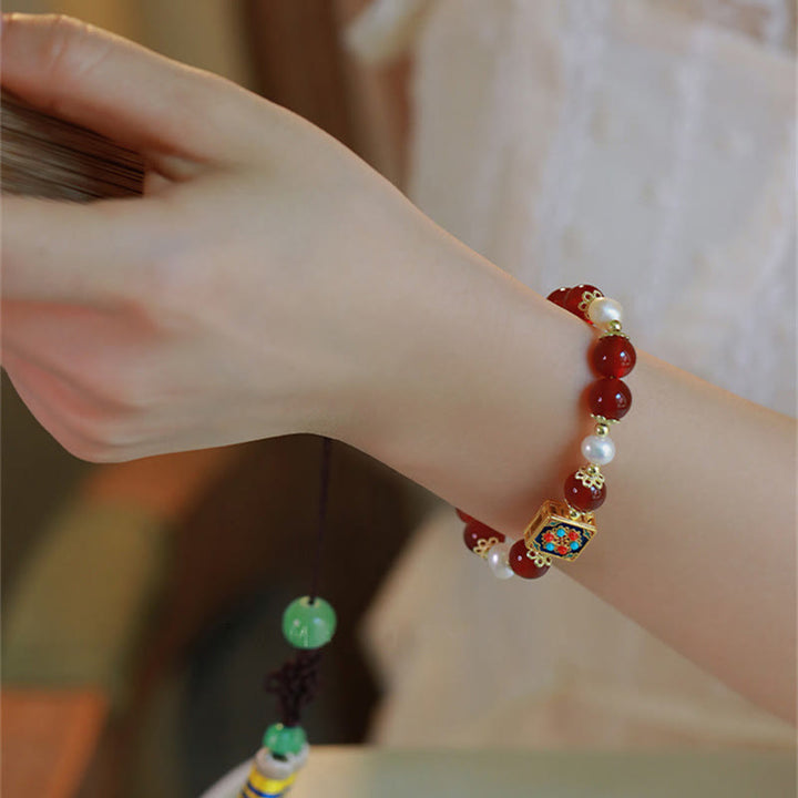 Armband Roter Achat Perle mit goldenen Elementen am Handgelenk getragen