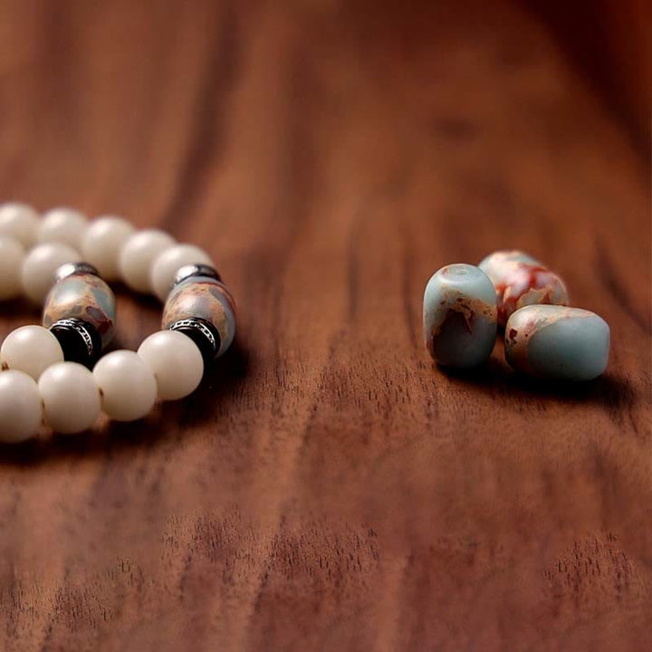 Mala Achat Bodhi – Wohlstand Armband mit weißen und grauen Perlen Holz.