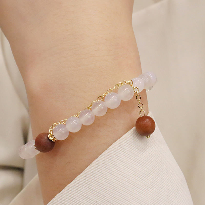 Armband Rosenquarz Sandelholz am Handgelenk elegantes Naturstein Design getragen