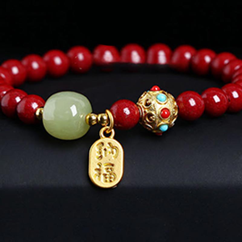 Armband Grüner Aventurin Zinnober mit goldenen Verzierungen auf schwarzem Hintergrund.