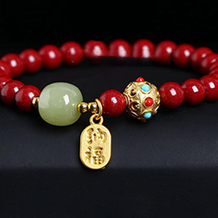 Armband Grüner Aventurin Zinnober mit goldenen Verzierungen auf schwarzem Hintergrund.