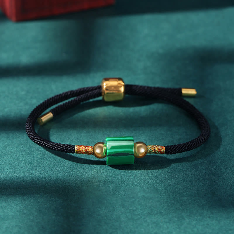 Grünes Malachit Armband mit schwarzem Seil und goldenen Perlen elegant.