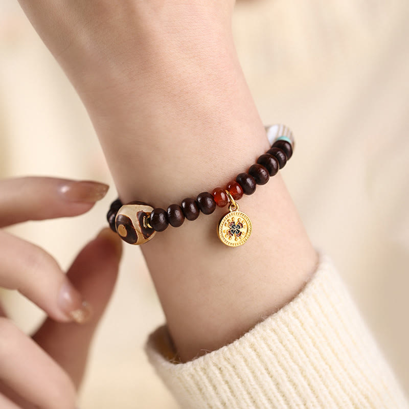 Bodhi Armband mit Goldmünze Anhänger am Handgelenk getragen braun