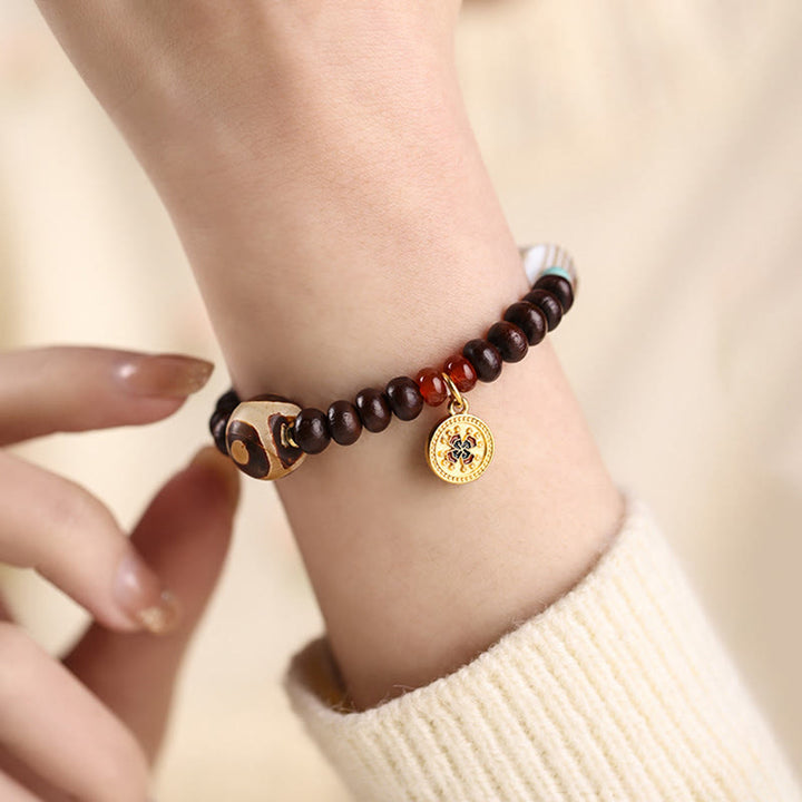 Bodhi Armband mit Goldmünze Anhänger am Handgelenk getragen braun