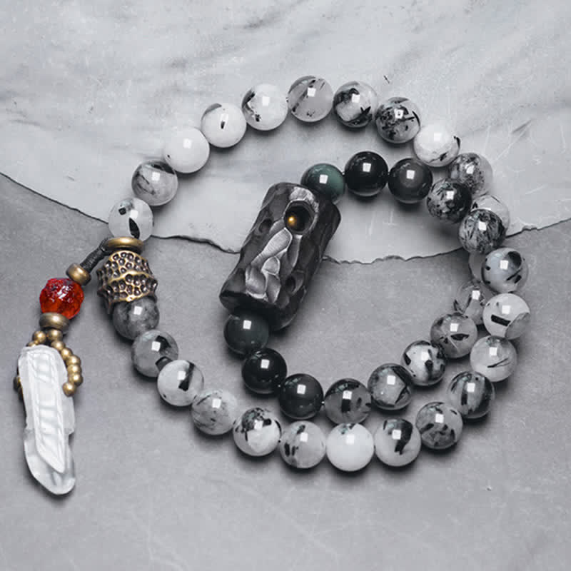 Armband mit weißem Kristall und Ebenholz auf grauem Untergrund.