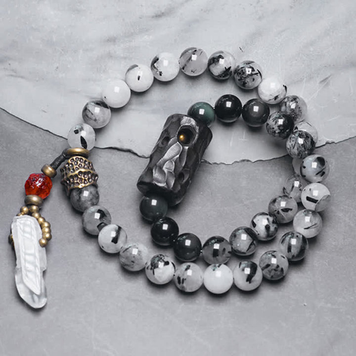 Armband mit weißem Kristall und Ebenholz auf grauem Untergrund.