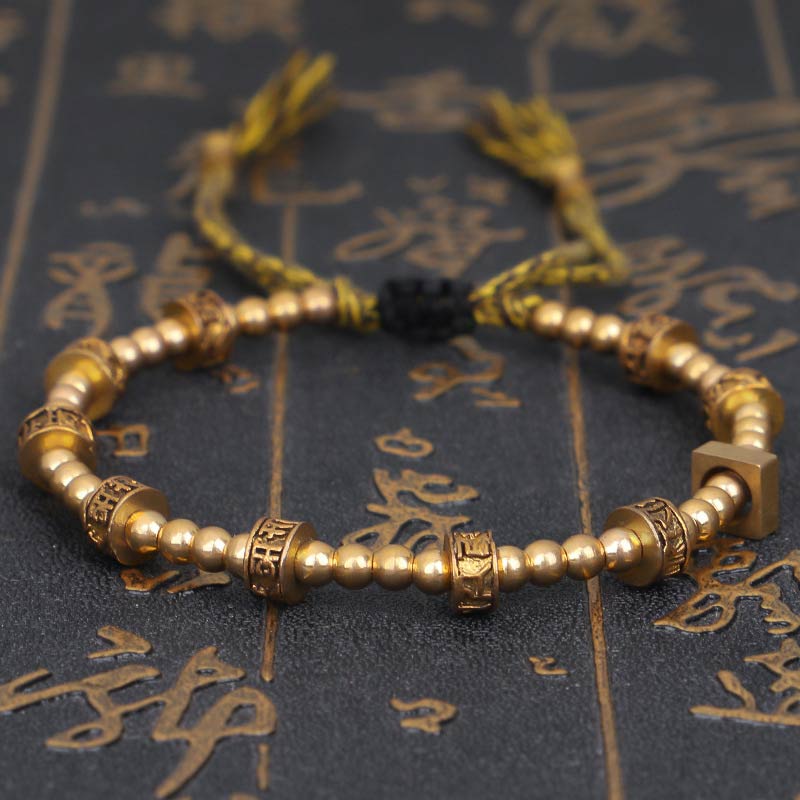 Tibetisches Armband mit goldenen Perlen und grünem Seil Knoten.