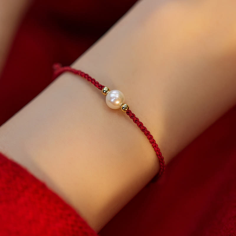 Armband Naturperle Geflochten am Handgelenk getragen rote Kordel weiße Perle