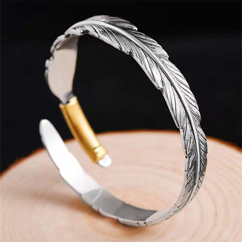 Silbernes Feather Armband Cuff mit graviertem Design auf Hand.