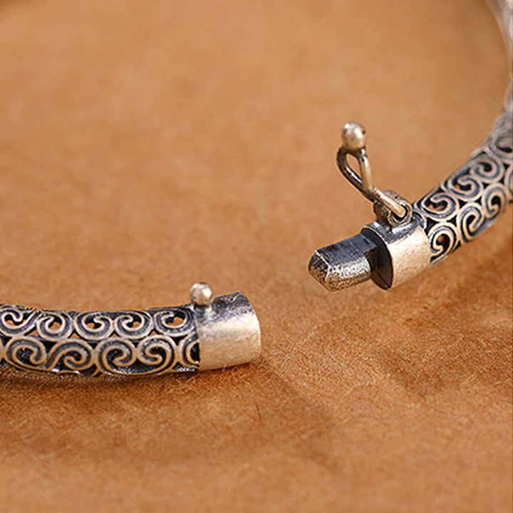 Silbernes Armband mit Spiralmuster und Perlendetails, elegant.