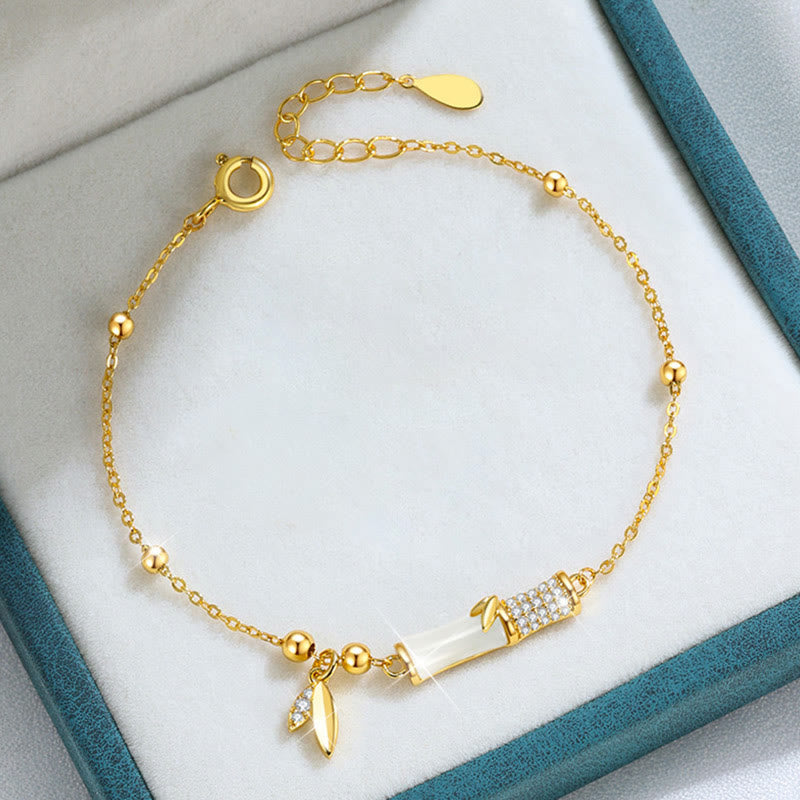 Elegantes goldenes Armband mit weißer Jade und Zirkonia Steinen.