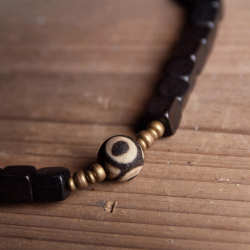Armband Kupfer Ebenholz Paar mit Perlen auf Holzoberfläche elegant