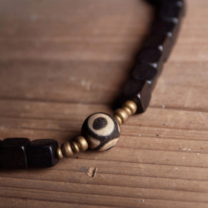Armband Kupfer Ebenholz Paar mit Perlen auf Holzoberfläche elegant