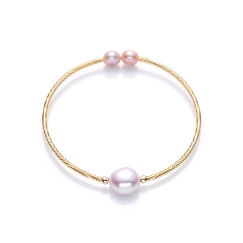 Armband Perle – Wohlstand mit rosa Perlen Goldfeder elegant glänzend.