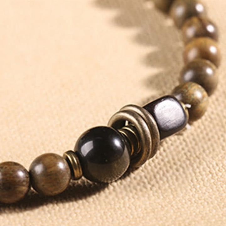 Armband Sandelholz Kristall – Frieden mit schwarzem Stein elastisch getragen