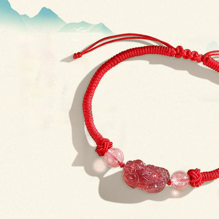 Rotes Armband mit Pixiu-Anhänger und Quarzperlen elegant präsentiert.