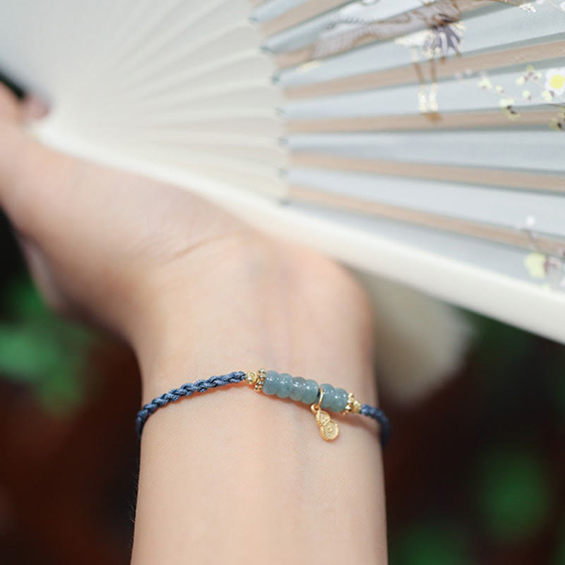 Blaues Jade Armband mit goldfarbenen Perlen am Handgelenk getragen