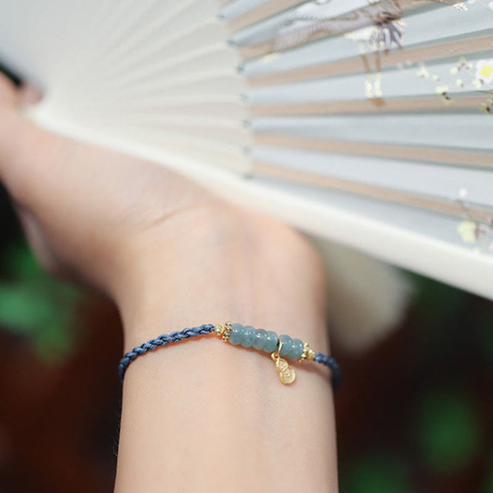 Blaues Jade Armband mit goldfarbenen Perlen am Handgelenk getragen
