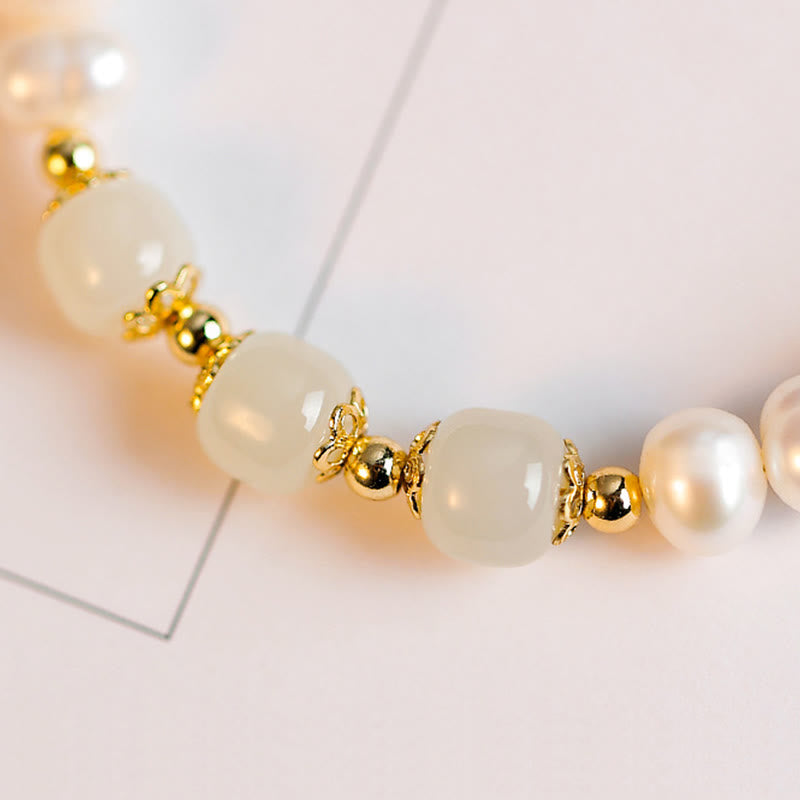 Armband Weiße Jade Goldperlen elegant auf weißem Hintergrund