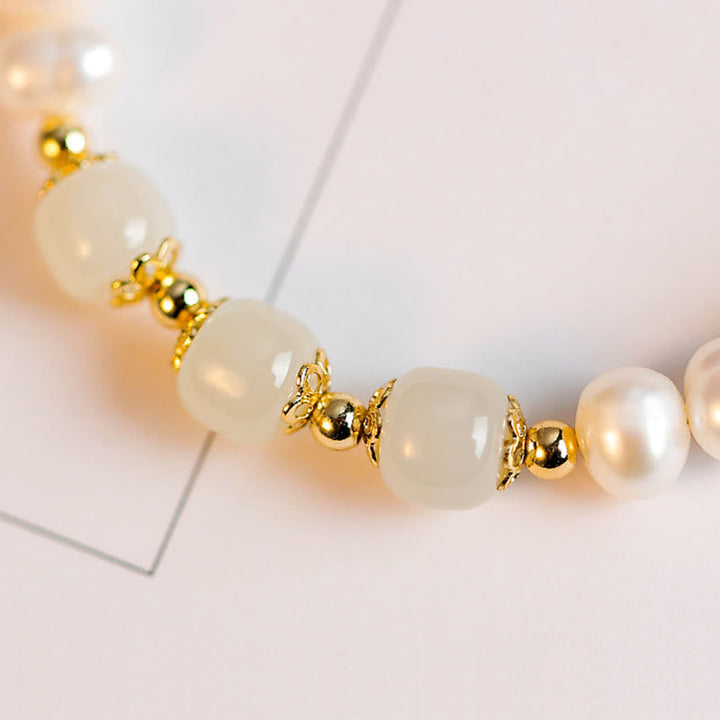 Armband Weiße Jade Goldperlen elegant auf weißem Hintergrund