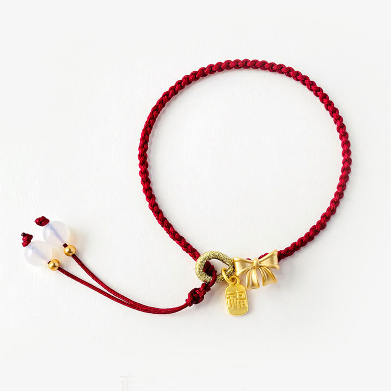 Rotes Armband Pfirsichblüte – Glück Energie mit goldenen Anhängern elegant.
