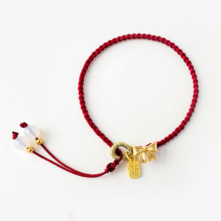 Rotes Armband Pfirsichblüte – Glück Energie mit goldenen Anhängern elegant.