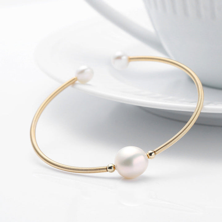 Goldenes Armband Perle – Wohlstand elegant auf weißem Hintergrund displayiert.