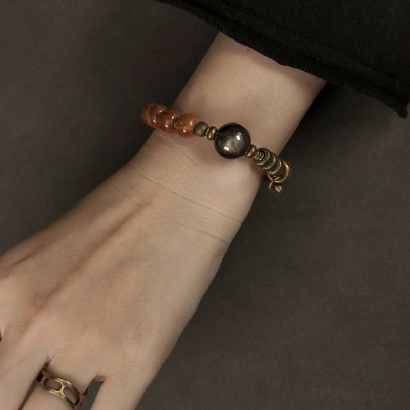Armband Tigerauge Obsidian mit braunen und schwarzen Steinen am Handgelenk.
