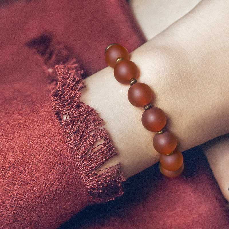 Armband Roter Achat Kupfer am Handgelenk getragen glänzende Natursteinperlen