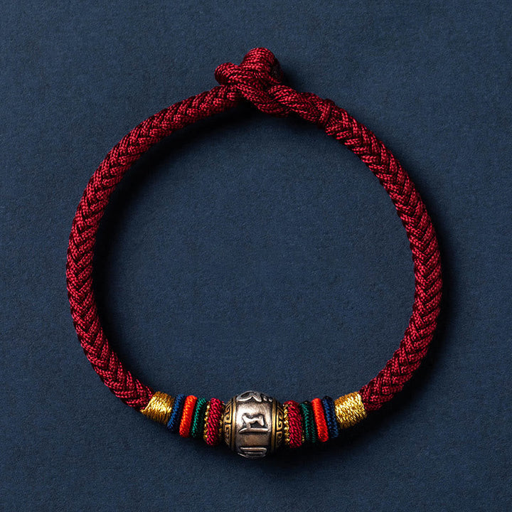 Rotes geflochtenes Armband mit silbernem Om Mani Padme Hum Anhänger elegant.