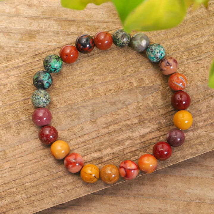Mala 108 Perlen Mookaite Emotional Armband bunte Natursteine Holzuntergrund.