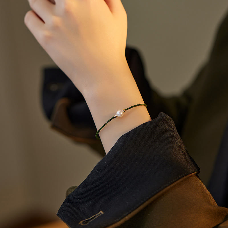 Armband Naturperle Geflochten am Handgelenk getragen schwarzes Lederband Perle