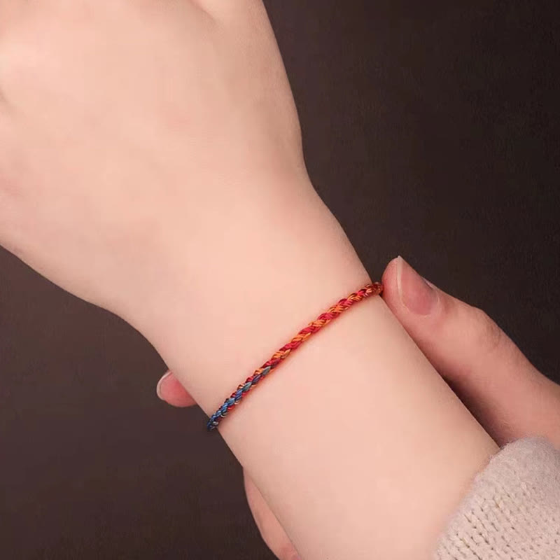 Buntes Glücksarmband am KindHandgelenk rot blau geflochten elastisch
