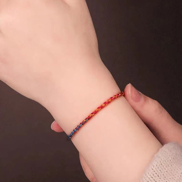 Buntes Glücksarmband am KindHandgelenk rot blau geflochten elastisch
