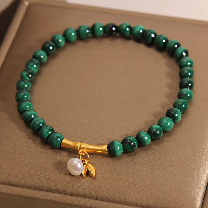 Armband Malachit grüne Perlen Bambus goldene Akzente elegant.