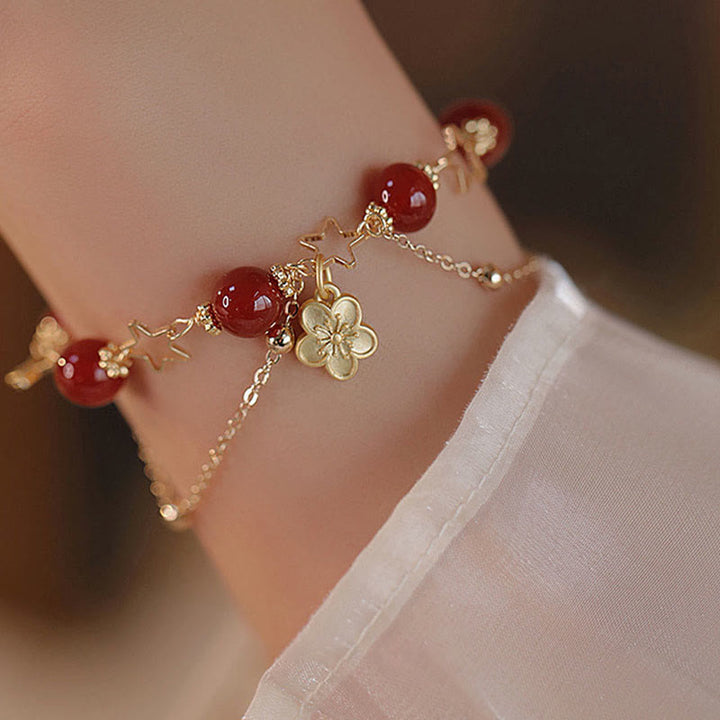 Armband Roter Achat Stern – Ruhe am Handgelenk mit goldenen Verzierungen getragen