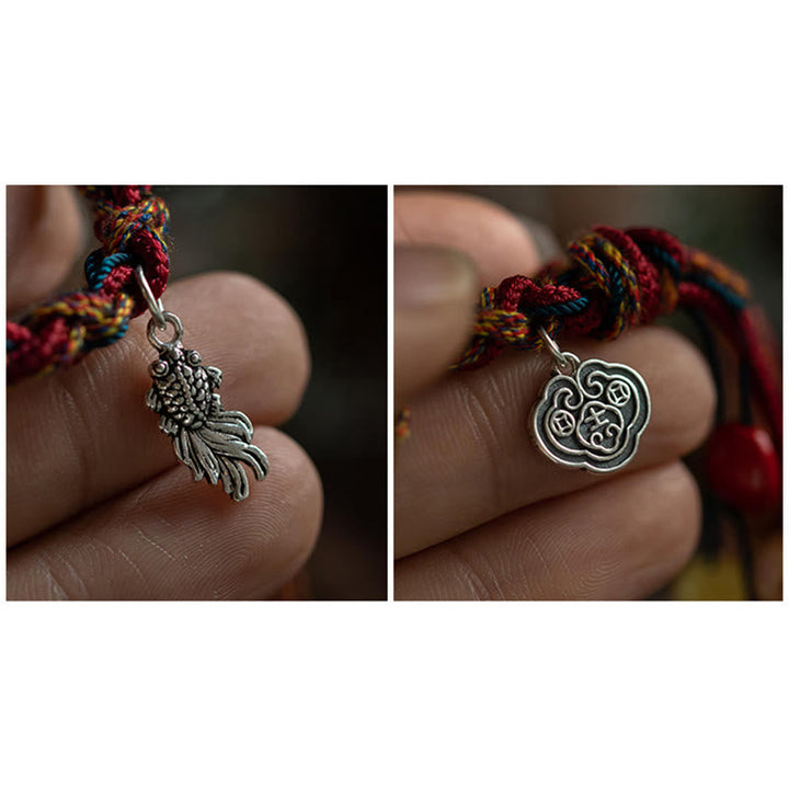 Armband 925 Silber Koi Fisch am Handgelenk mit buntem Seidenfaden getragen