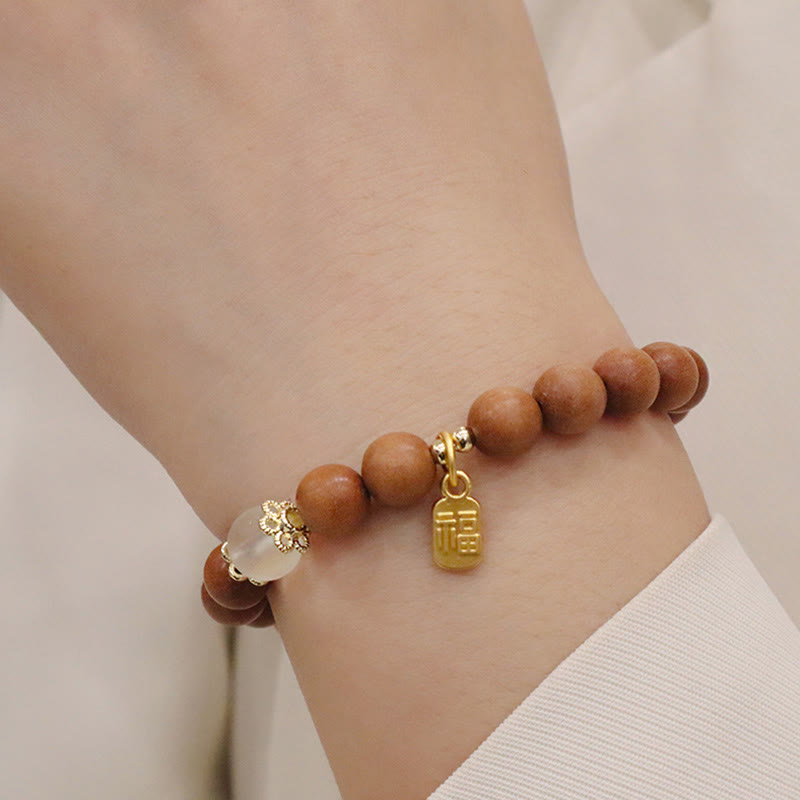 Armband Sandelholz Fu-Zeichen am Handgelenk, goldene Charms, Schutz.