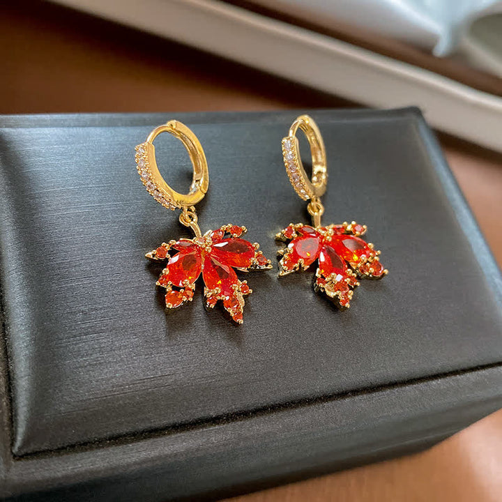Goldene Ohrringe mit roten Zirkonia Ahornblatt Anhängern glänzend